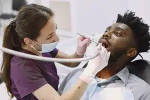 young african american man guy visiting dentist s office for prevention of the oral cavity man and famale doctor while checkup teeth